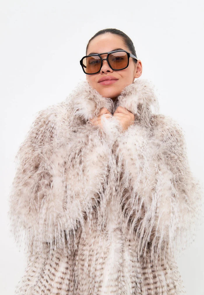 A fashionable women's long faux fur coat in winter style, featuring a belted design for a trendy look.