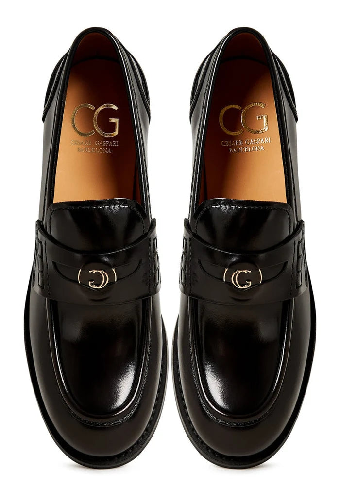A stylish pair of women's black leather loafers with a chunky block heel, known as Dinara black shoes.