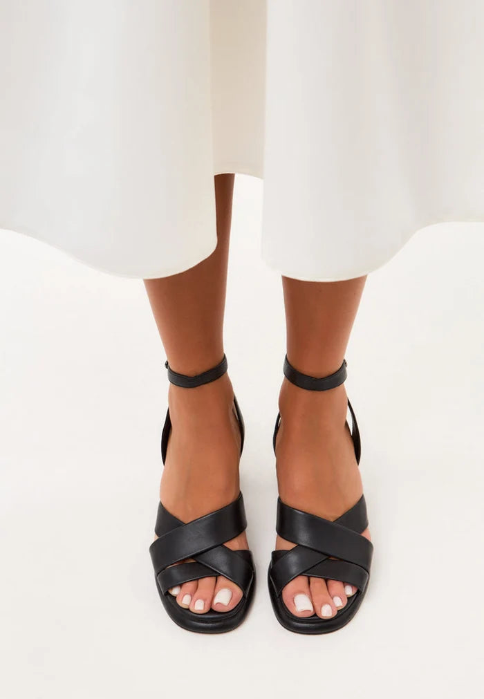 A stylish pair of black block heeled sandals known as the Evelyn Black Block Heels, giving a chic and trendy look for any outfit.