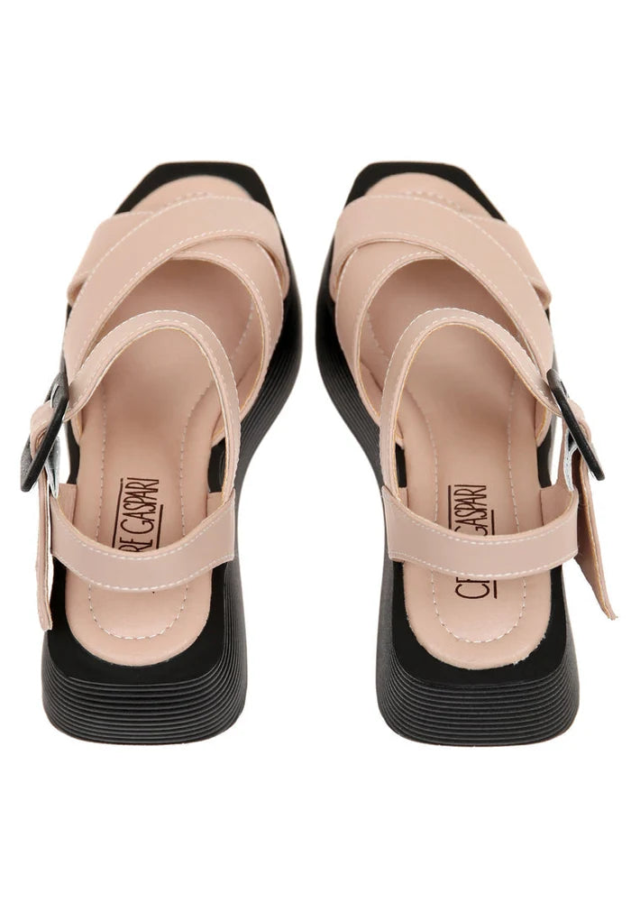 A stylish pair of women's blush pink platform sandals with strappy details and high heels.