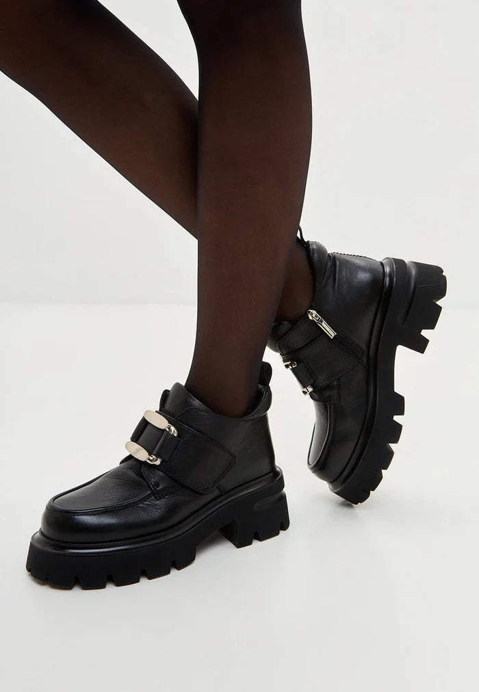A pair of sleek black leather double buckle Geirr loafers, a bold choice in men's fashion footwear.
