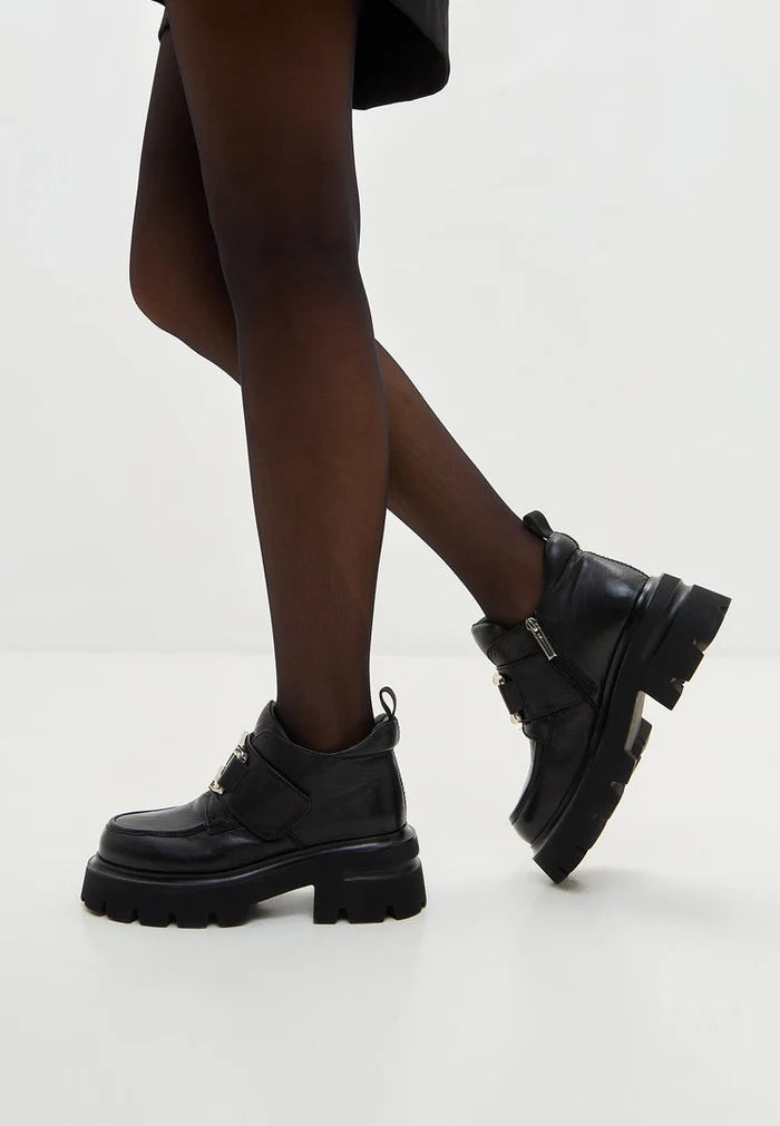 A stylish pair of black leather double buckle Geirr loafers, a bold choice in men's fashion footwear.