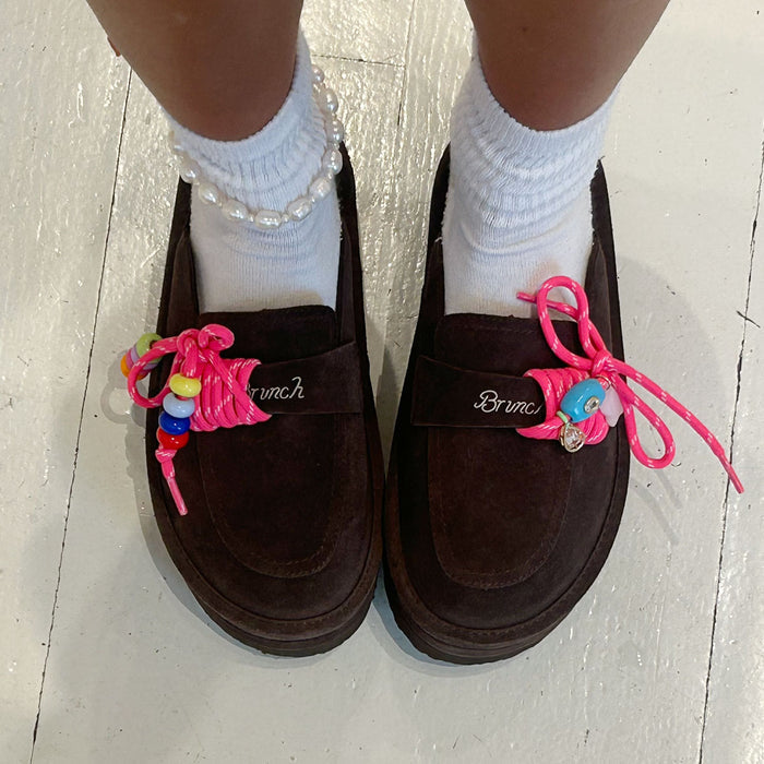 Top view of Carrie Charm Kit laces showcasing hot-pink paracord laces with colorful beads on dark brown suede loafers