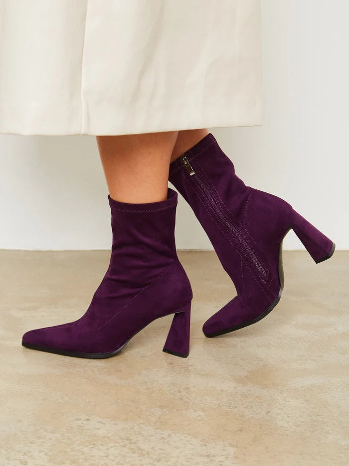 A pair of stylish purple suede ankle boots with block heel, perfect for a casual and trendy look.
