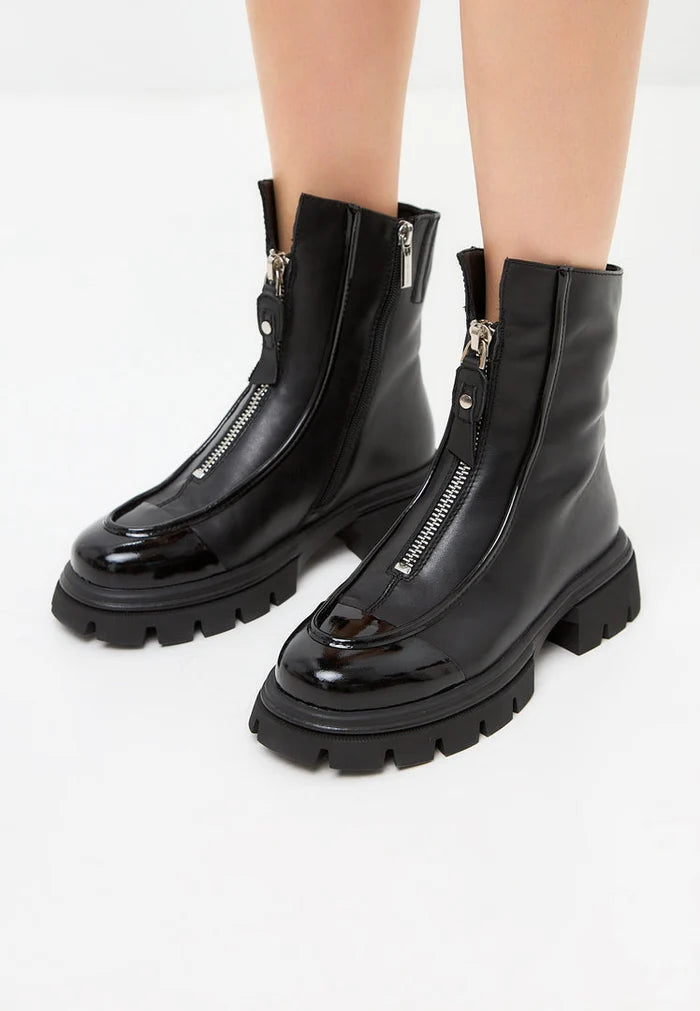 A close-up photo of black chunky zipper ankle boots, perfect for adding a touch of edge to any outfit.