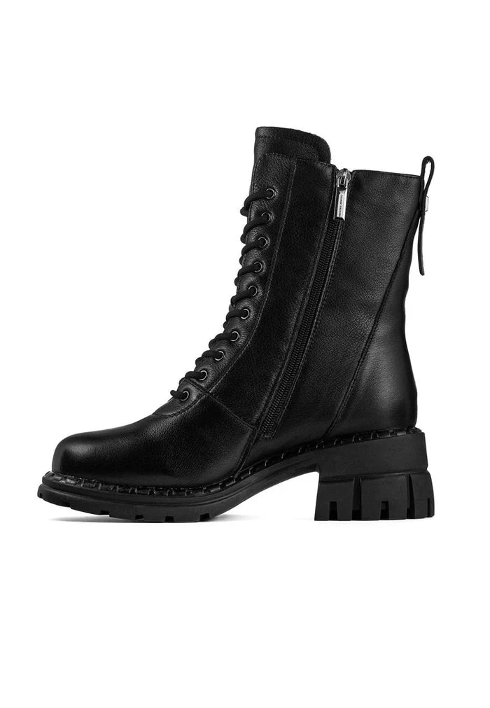 A fashion-forward woman steps out in a pair of classic block heeled boots, elevating her style with these chic and trendy high heeled women's boots.