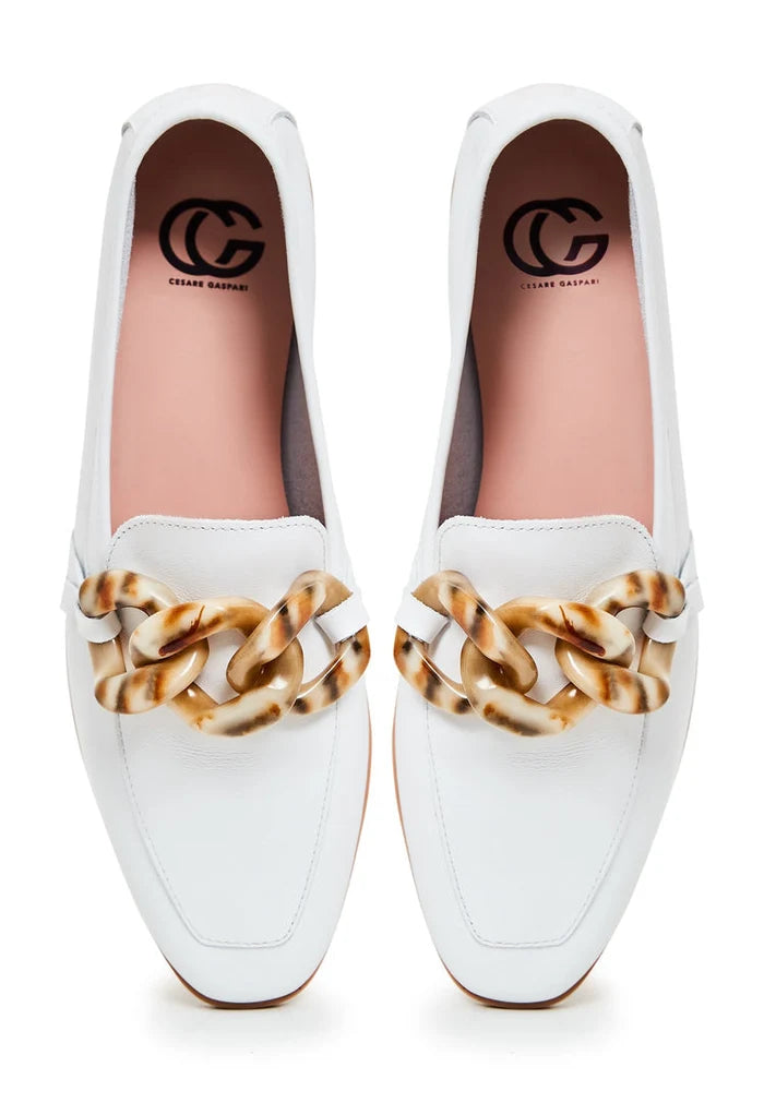 A pair of stylish white leather flat loafers with a classic design and a flat sole, perfect for any occasion.