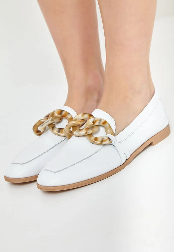 A stylish pair of white leather loafers with a flat sole, embodying classic footwear elegance.