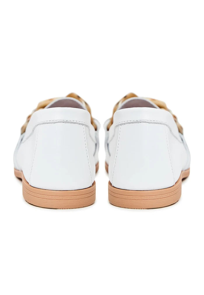 A close-up image of stylish white leather loafers with a flat sole, a classic choice for versatile footwear.