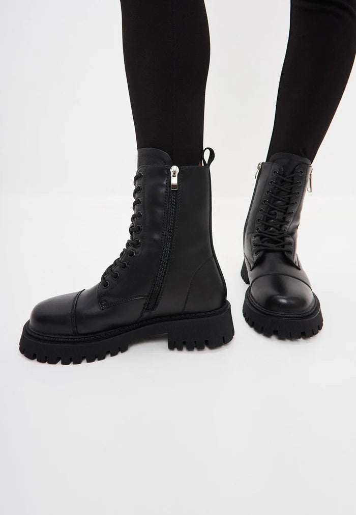 A stylish pair of black leather platform ankle booties, the perfect classic footwear choice for women.