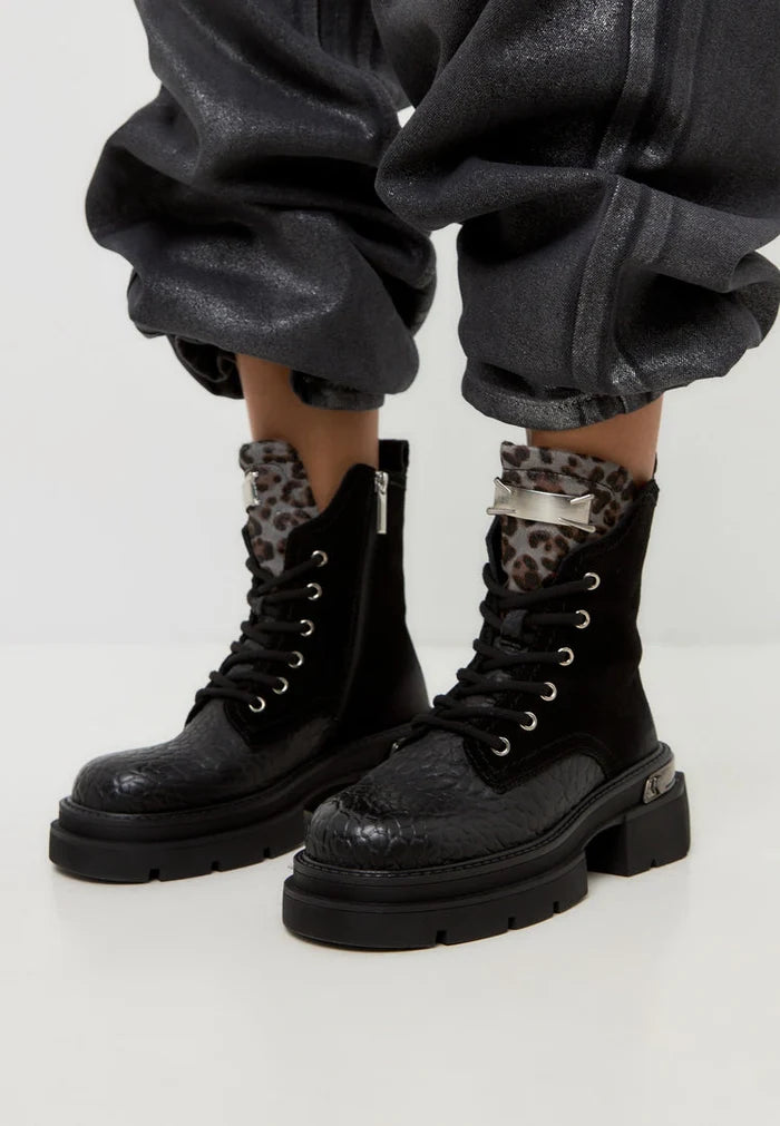A stylish pair of Luna ankle boots in black suede with platform heels, making them a classic choice for any outfit.