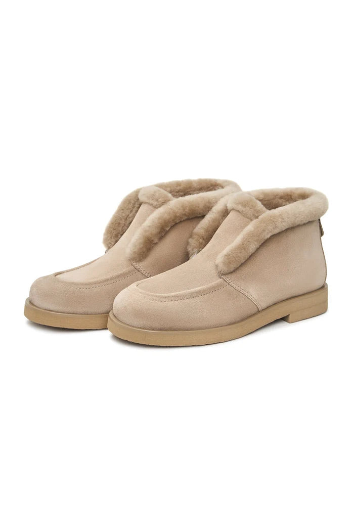 A pair of cozy Gerda beige suede fur-lined boots, perfect for staying warm and stylish during the winter season.