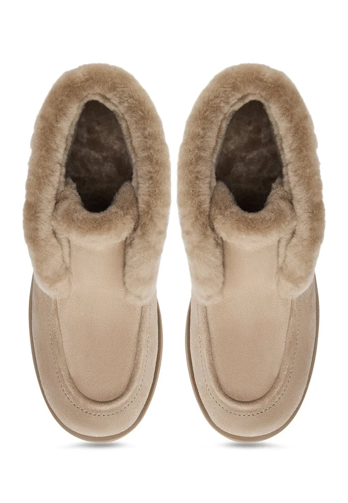 Stay warm and stylish this winter with a pair of Gerda beige suede fur-lined boots, perfect for cold weather.