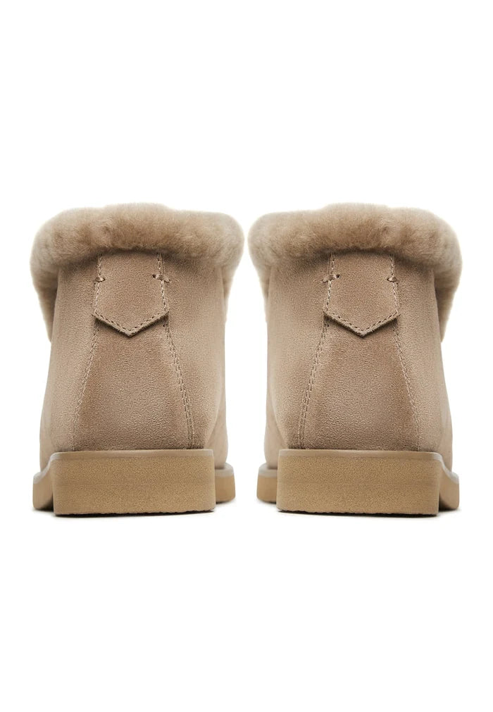 A pair of cozy winter Gerda beige suede fur-lined boots for women, keeping feet warm and stylish during the cold season.
