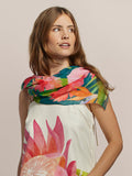 White Deco Bouquet print scarf with white dress, woman gazing left, plain background.