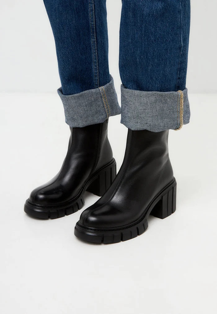 A pair of trendy ankle boots with a chunky heel, perfect for adding a touch of style to any outfit.