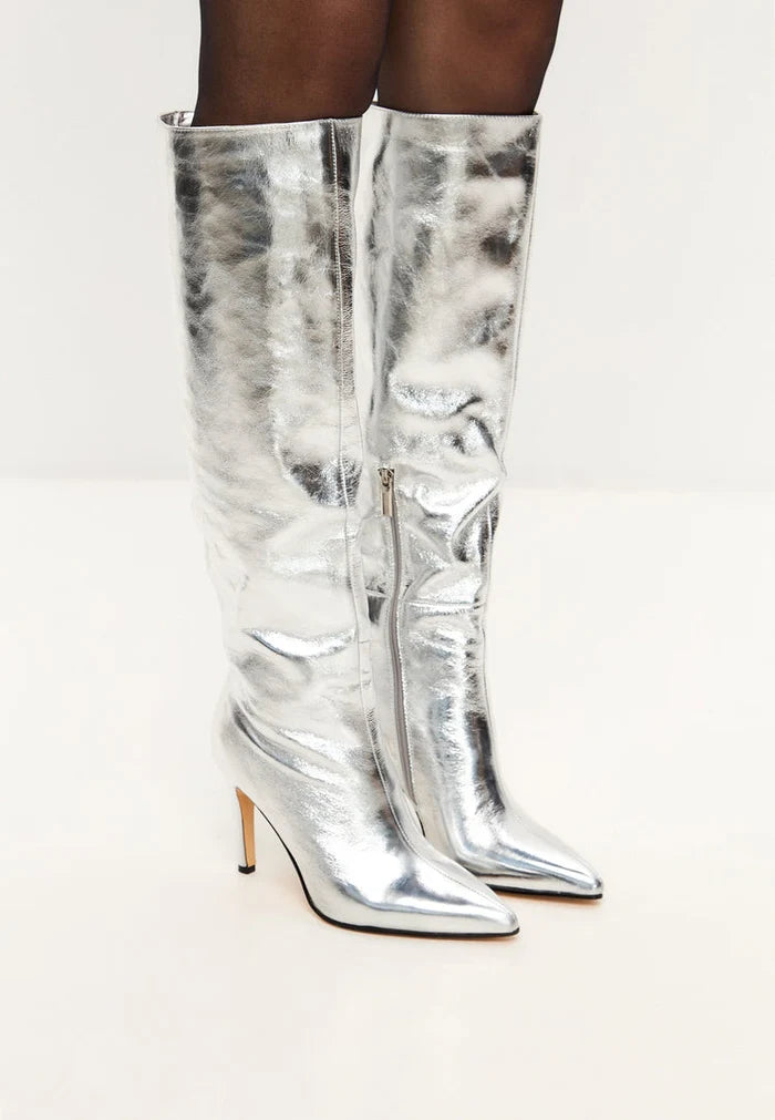 A stylish pair of silver knee-high boots, perfect for making a trendy statement with their high heel and metallic finish.
