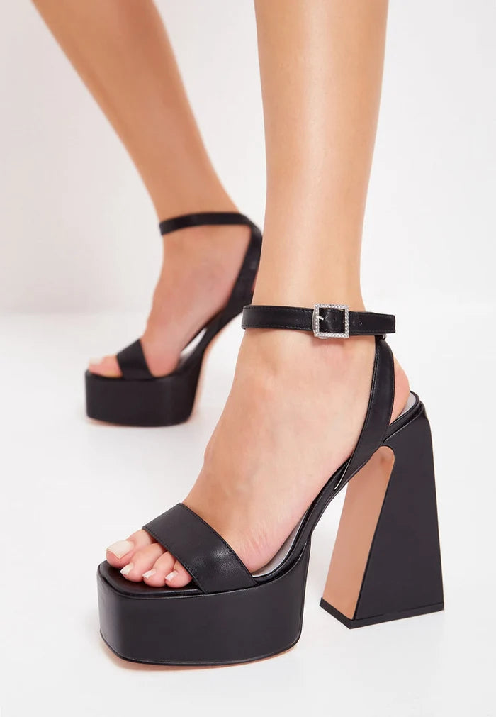 A pair of elegant black elevated sandals with a sleek and modern design.