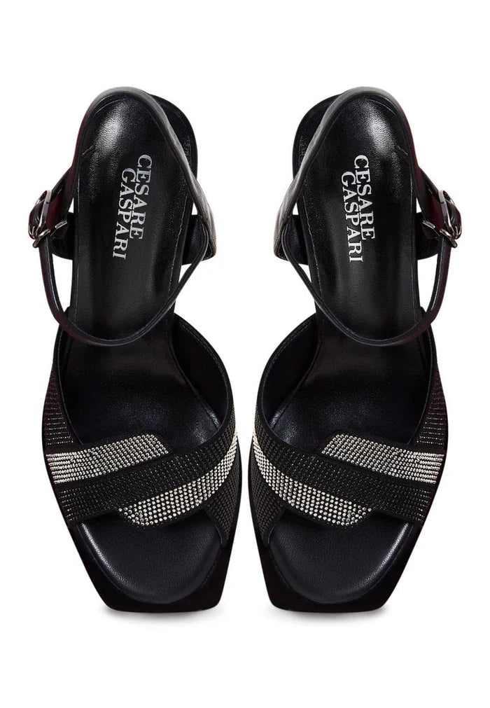 Pair of elegant black elevated sandals on a white background.