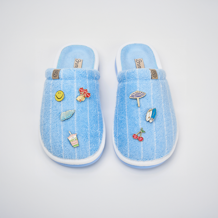 Top view of Essential Cabana striped terry slippers with blue cabana stripes, enamel charms, and white trim on white