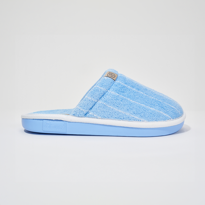 Side view of The Essential slipper in Cabana striped terry showing white trim and blue sole on white
