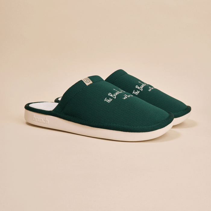 Three-quarter view of green Essential slipper with embroidered Beverly Hills Hotel script on knit upper and white EVA sole