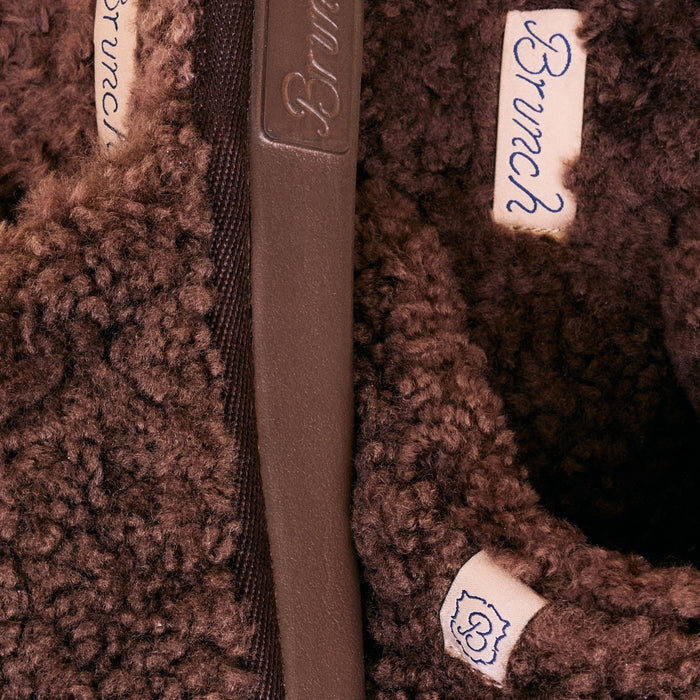 Close-up of Essential All Shearling slipper interior showcasing plush brown shearling lining and embossed rubber sole edge
