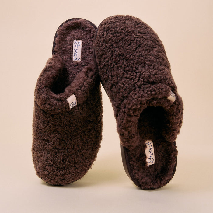Angled front view of brown Essential All Shearling slipper showcasing plush shearling upper and visible Brunch label on a cream background