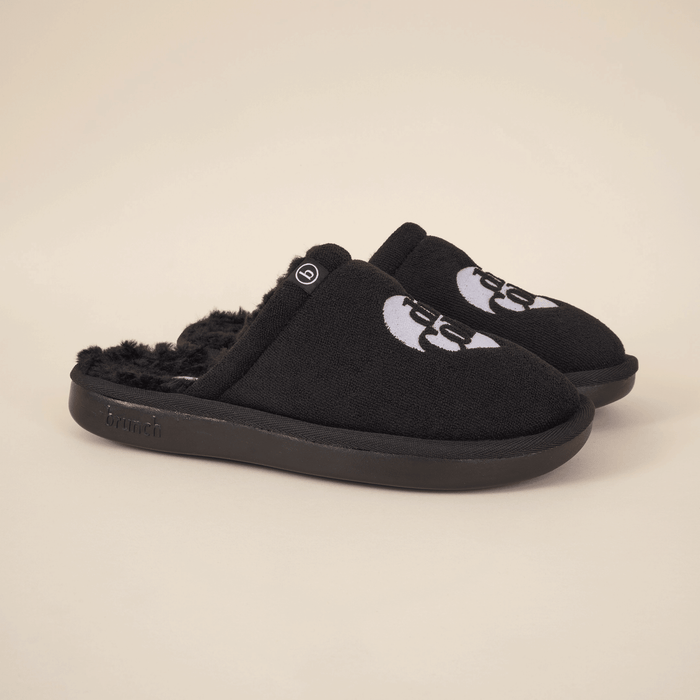 Three-quarter view of black Diet Coke x Brunch shearling slippers with faux-shearling lining, embroidered logo, and black sole