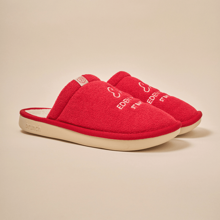 Three-quarter view of Essential Eden Rock slipper in red with embroidered logo, terry upper, and cream outsole on neutral background