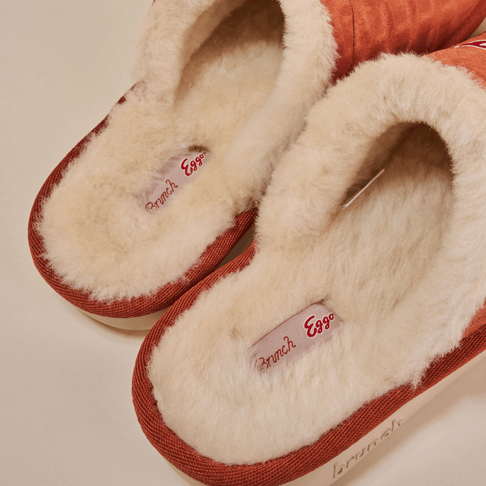 Top down view of Essential Eggo slippers in Syrup showing plush cream shearling lining and red suede upper