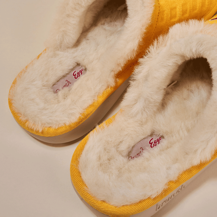 Top-down view of Essential Eggo slippers in yellow showcasing plush cream shearling lining and Eggo logo insole on a neutral background