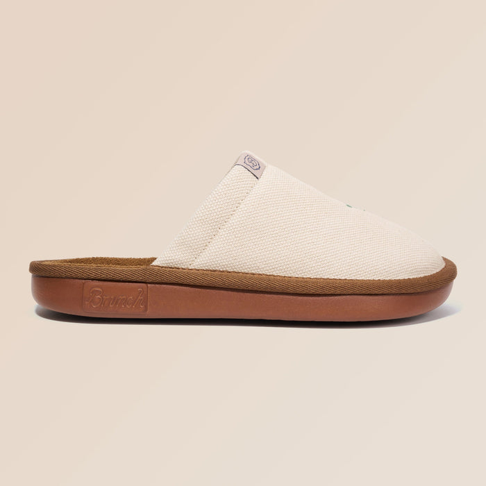 Side view of beige Essential Floral canvas slipper with sunflower embroidery and brown cushioned sole on neutral background