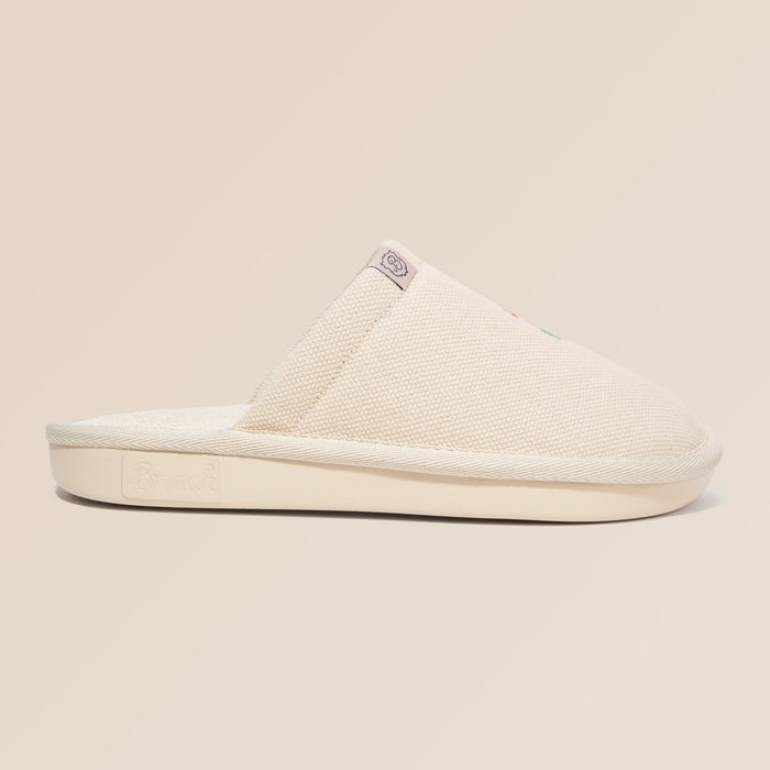 Side view of Essential Floral canvas slipper in beige Wildflower showcasing hand-stitched floral embroidery on a neutral beige background