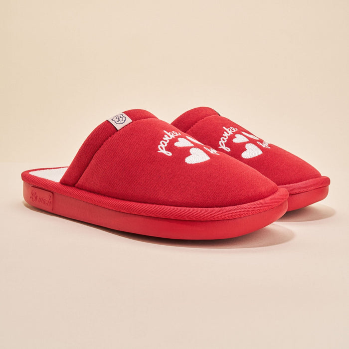 Three-quarter view of Essential Parke crimson fleece slippers showcasing white embroidered hearts and Parke script on a neutral beige background