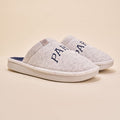 Angled view of pair of Essential Parke Varsity fleece slippers with embroidered PARKE lettering, cushioned white sole on beige