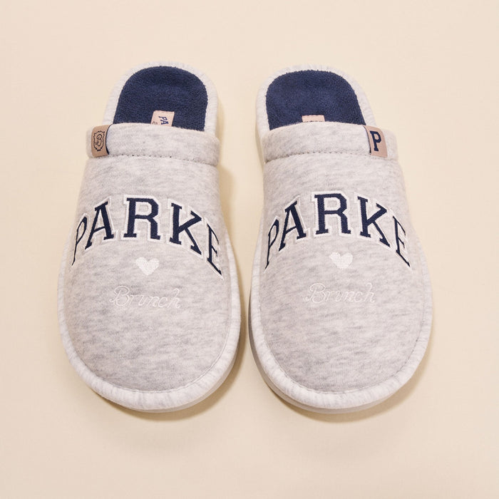 Top-down view of Essential Parke Varsity fleece slippers showing embroidered PARKE lettering and navy terry lining on a beige background