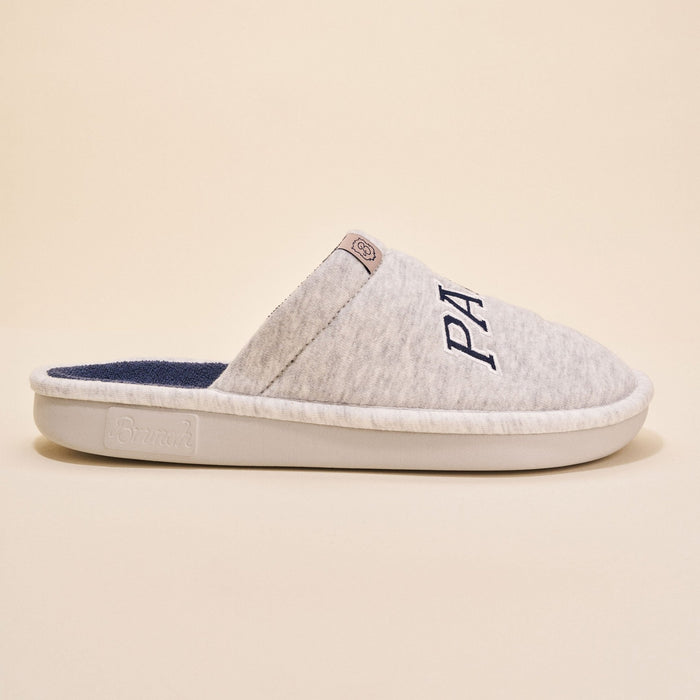 Side view of Essential Parke Varsity fleece slipper showcasing light gray fleece upper, navy terry lining, embroidered PA logo on beige background