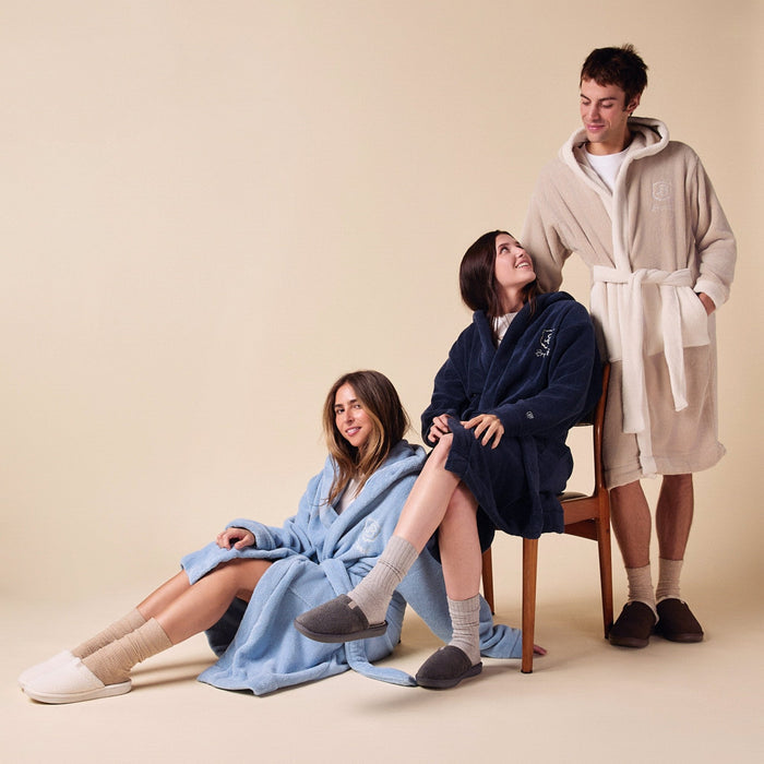 Group of three wearing Essential Robes in beige, navy, and powder blue with oversized plush terry fit on a neutral background
