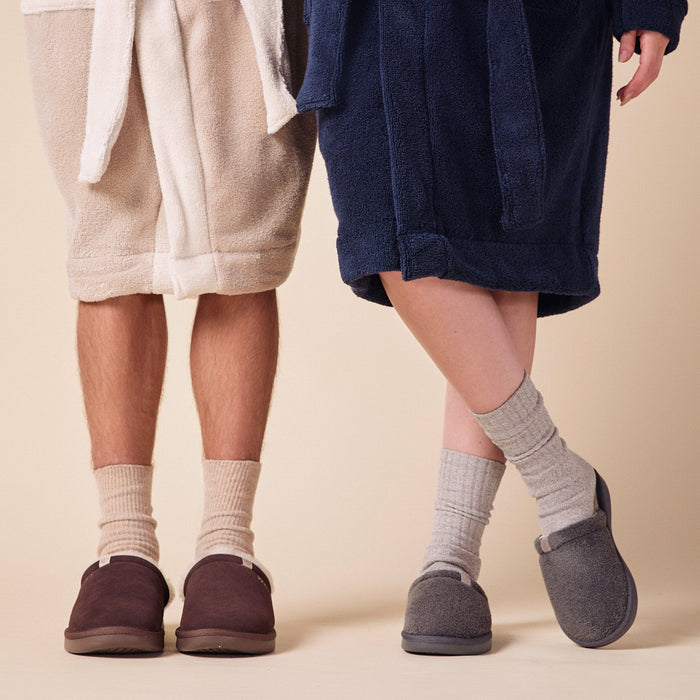 Cropped front view of Essential Robe in navy showcasing oversized fit, belted waist, and patch pockets against a neutral beige background