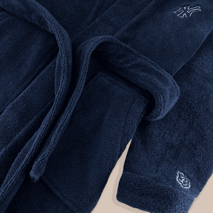 Close-up of navy Essential Robe showing plush terry texture, hood edge, belt, and embroidered Yankees and Brunch crests