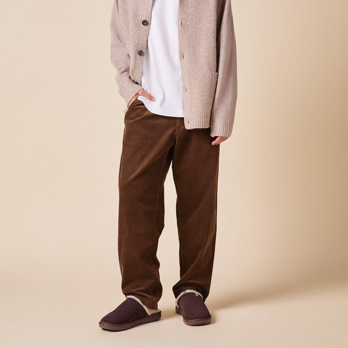 Front view of Essential Shearling suede slippers on model showing plush shearling lining and low profile sole on beige background