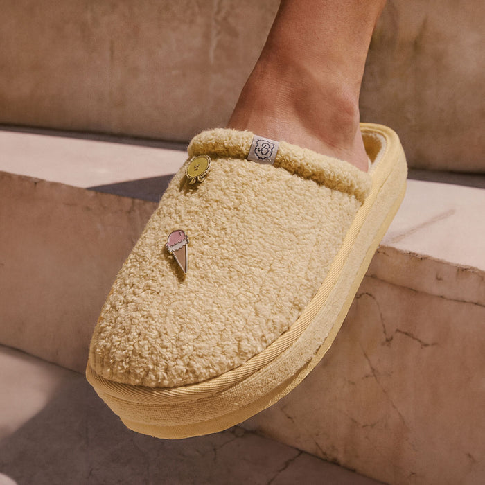 Close-up of Limoncello Essential XXL Ribbed Terry slipper on foot showcasing plush ribbed texture and two enamel charms with marble step background