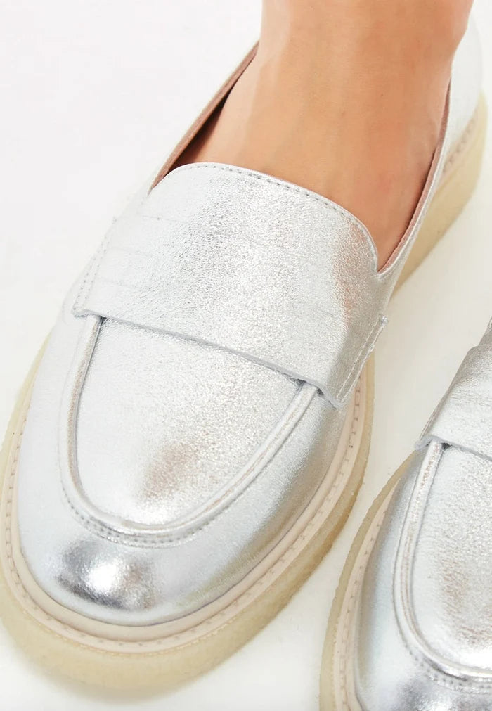 Stylish silver slip-on loafers with a flat sole for women's fashion statement.