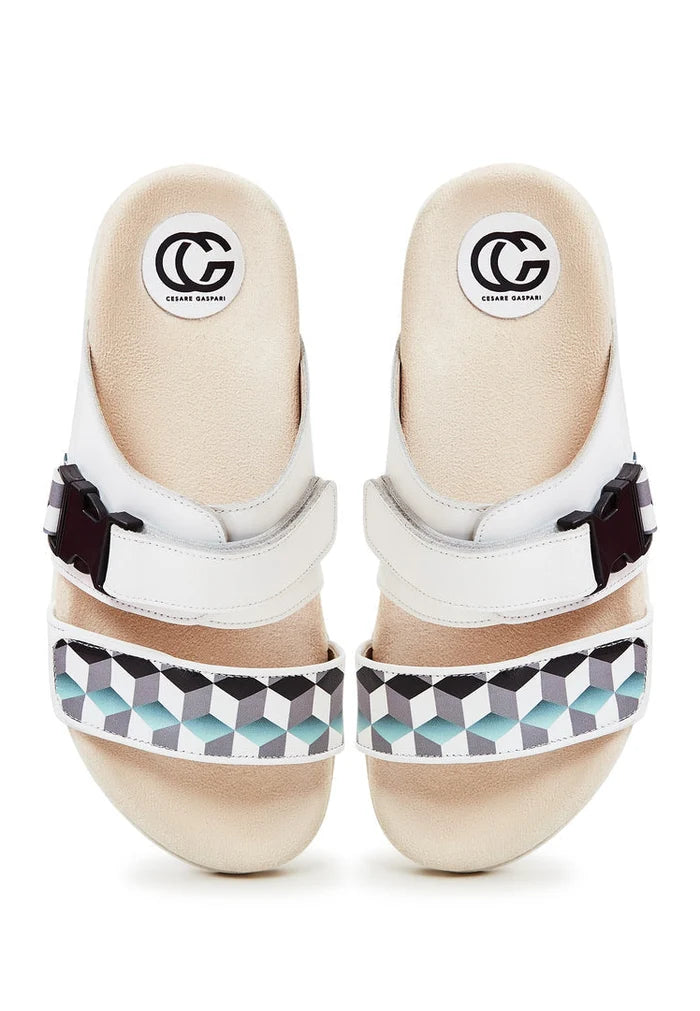 A pair of chic white Meredith mules with a flat sole, perfect for summer days and women's footwear fashion.