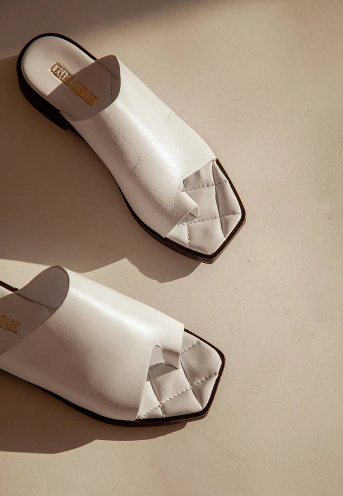 A close-up of flat sole, one toe loop, minimalist sandals that are stylish and comfortable for everyday wear.
