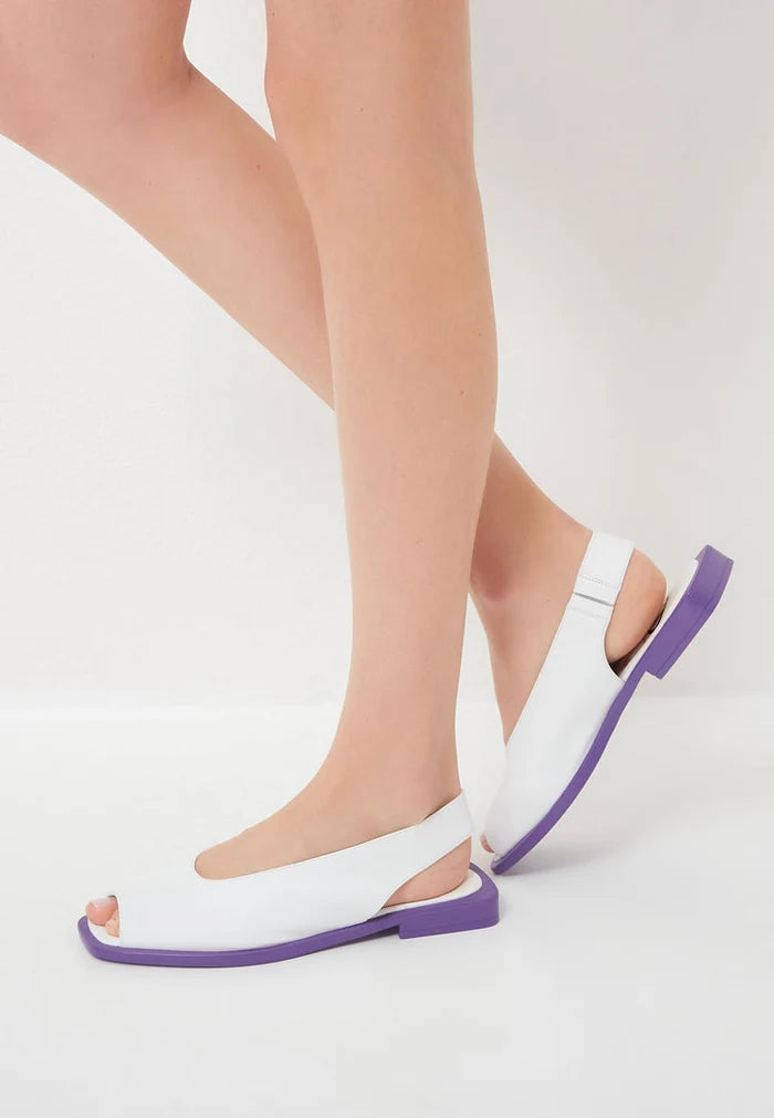 A pair of white flat sole women's sandals, perfect for summer and casual wear.