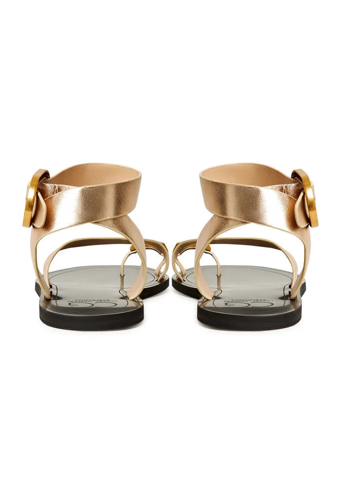 A pair of stylish gold Paula flat sole women's sandals perfect for casual wear.