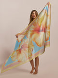 Pastel blue pareo with yellow-orange hibiscus print, held full length by barefoot woman.