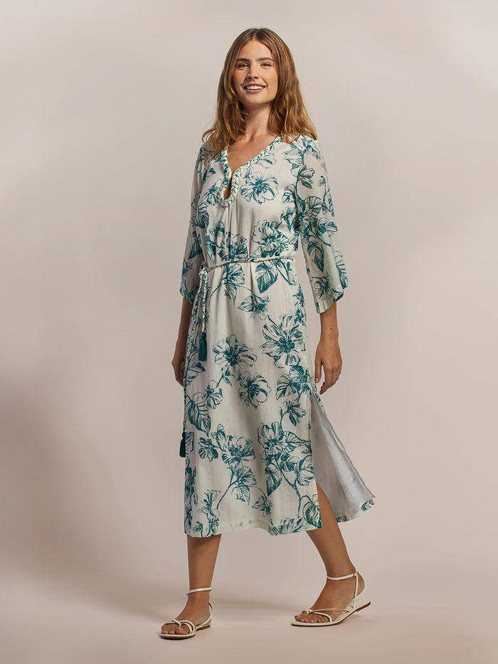 Blue-green patterned Hau Mae caftan dress, full front view with model’s hair loose.